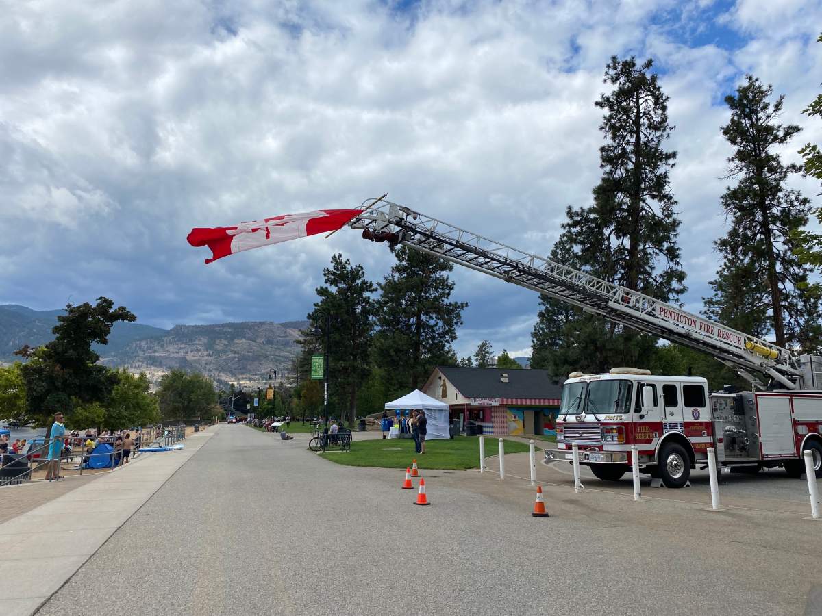 A Canadian flag is flown from a fire engine in honour of fallen B.C. wildland firefighter Zak Muise.
