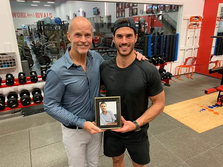 Steven Finn (left) and son Sam Finn hold a portrait of Cedric Finn on Aug.3, 2023. Gloria Henriquez/Global News