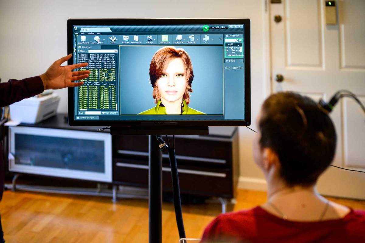 Ann Johnson sits in front of a digital avatar, through which she can speak out loud via a brain-compter interface.