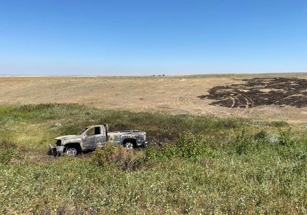 A burnt truck sits in a field on the Blood Tribe.