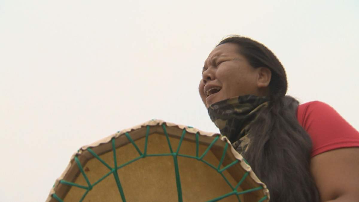 A woman sings and drums a traditional song at Camp Morgan near the Brady Road Landfill on Friday, August 4, 2023.