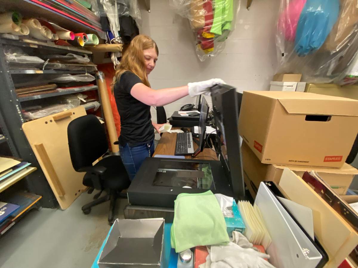 Shayda Spakowski scans on of the more than 100,000 negatives at risk in the CNE archive collection