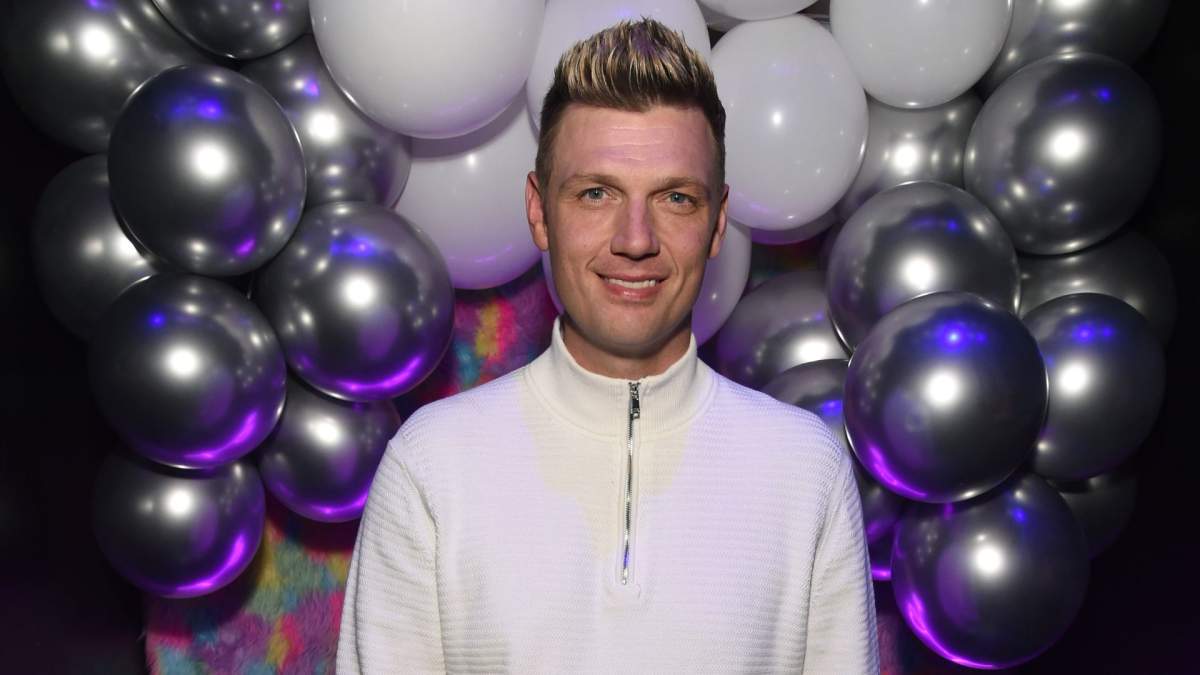 Nick Carter in a white half zip sweater.