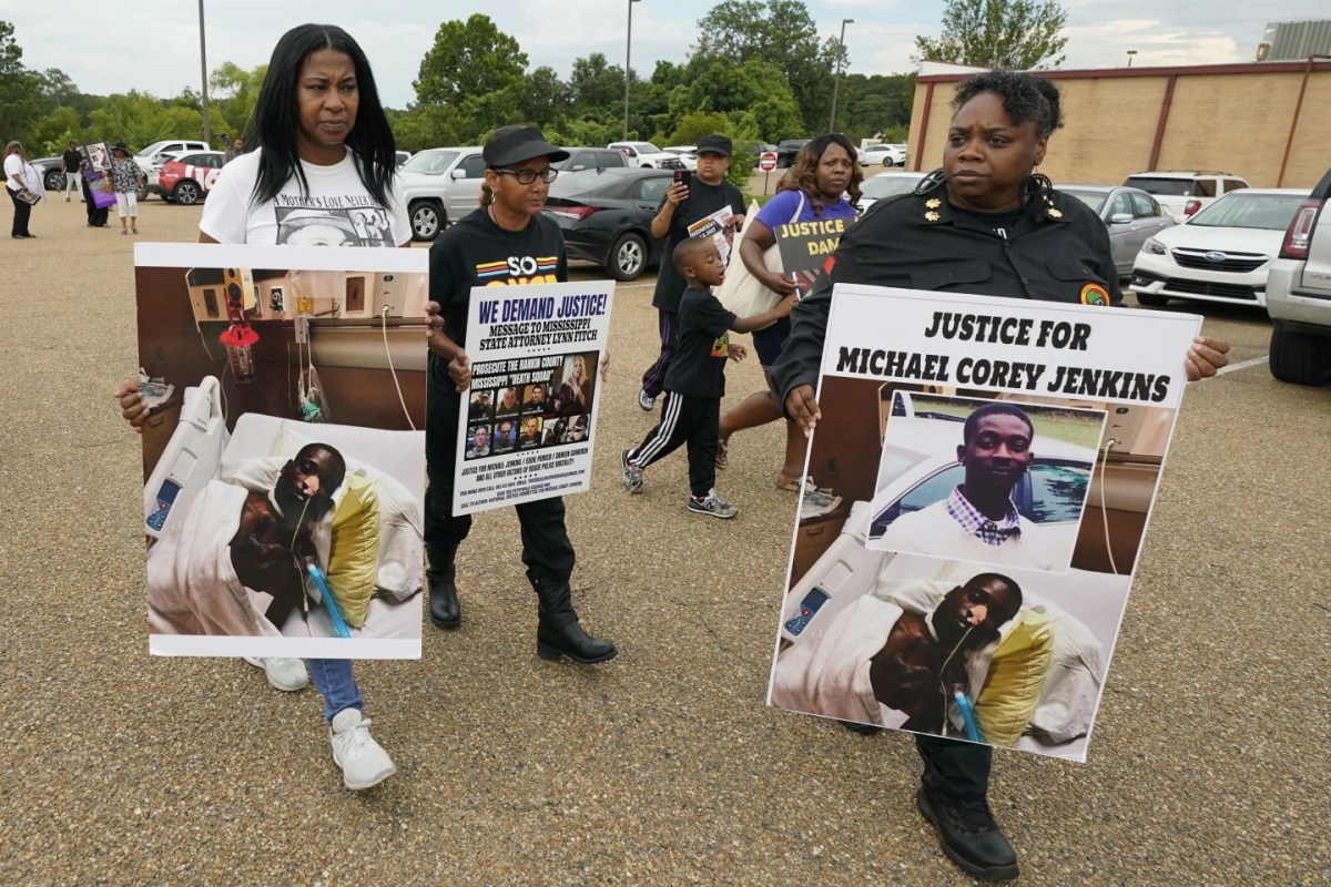 Activists hold signs calling for justice for the victims.