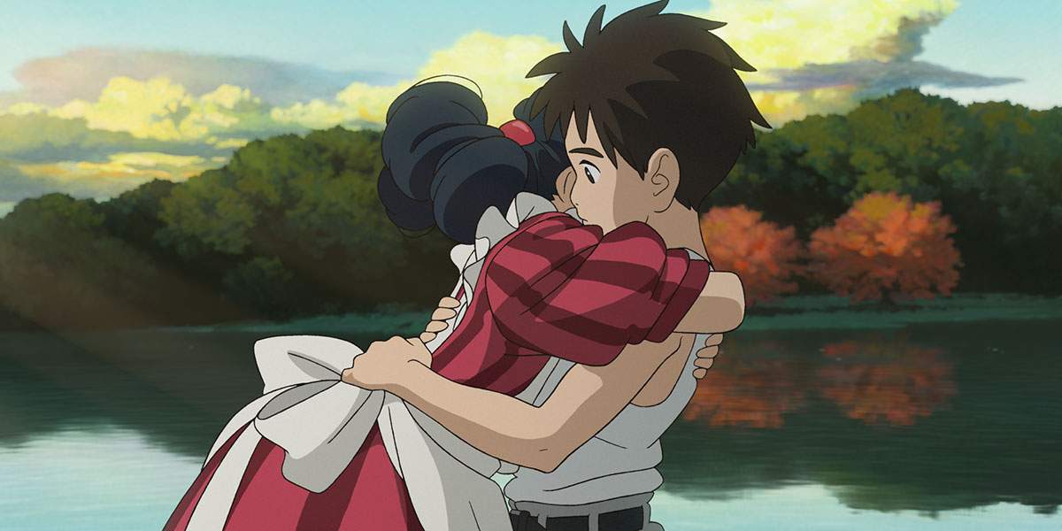 An animated still from 'The Boy and the Heron.' A young boy hugs a woman in a striped, red dress and white apron.