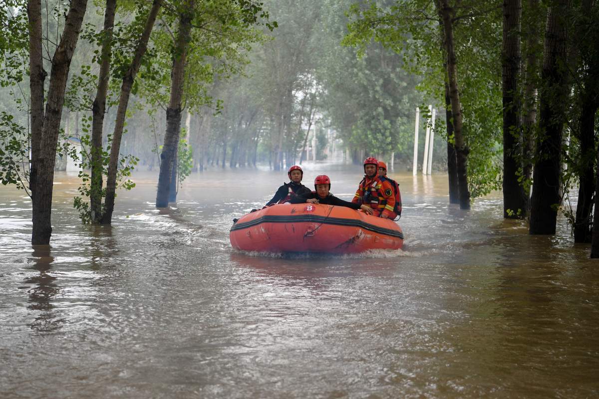 In this photo released by Xinhua News Agency, rescuers ride a rubber boat and head to a village to carry out evacuation operation in the flood-hit Zhuozhou in northern China’s Hebei province on Thursday, Aug. 3, 2023.