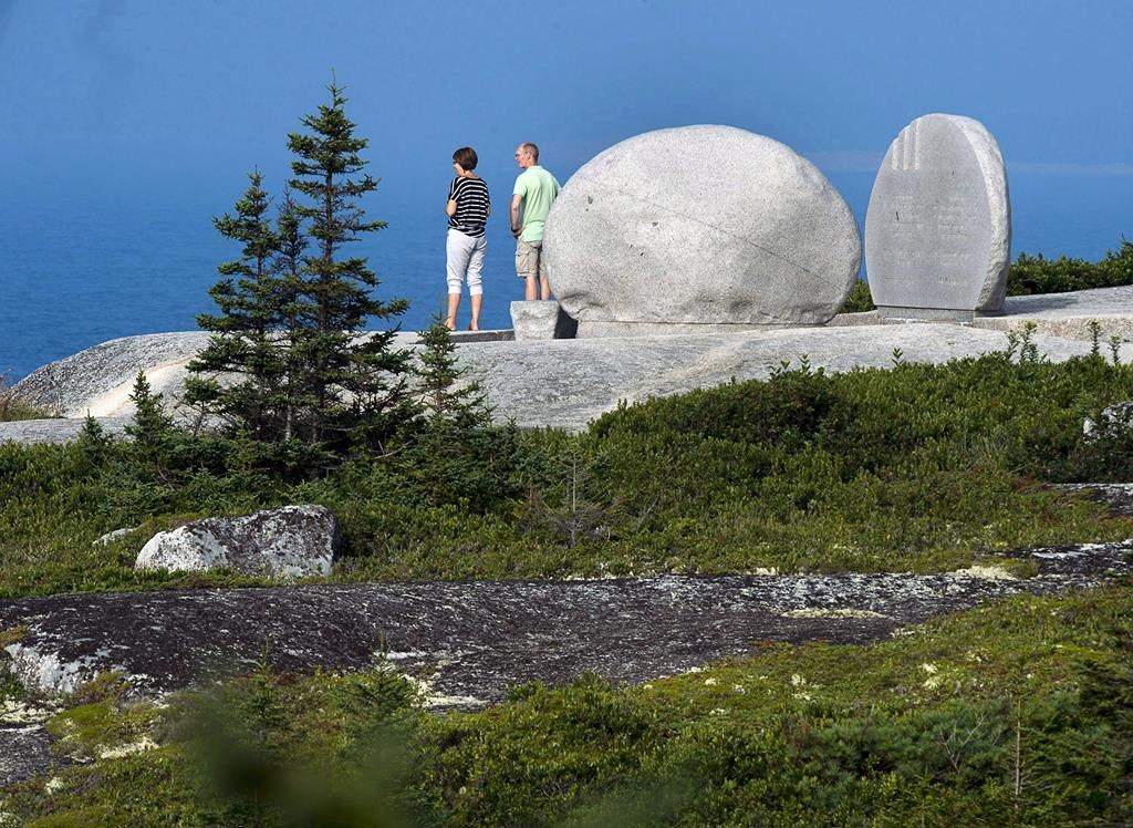 A delegation of Canadian military veterans, RCMP officers and first responders are commemorating the 25th anniversary of Operation Persistence, Canada's military response to the Swissair Flight 111 crash. Visitors look out to the ocean from the Swissair Flight 111 memorial at Whalesback near Peggy's Cove, N.S. on Thursday, Aug. 30, 2018. THE CANADIAN PRESS/Andrew Vaughan.
