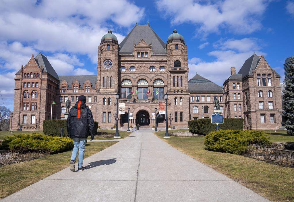 A man walks in front of Queen’s Park in Toronto, Monday, Feb. 20, 2023.