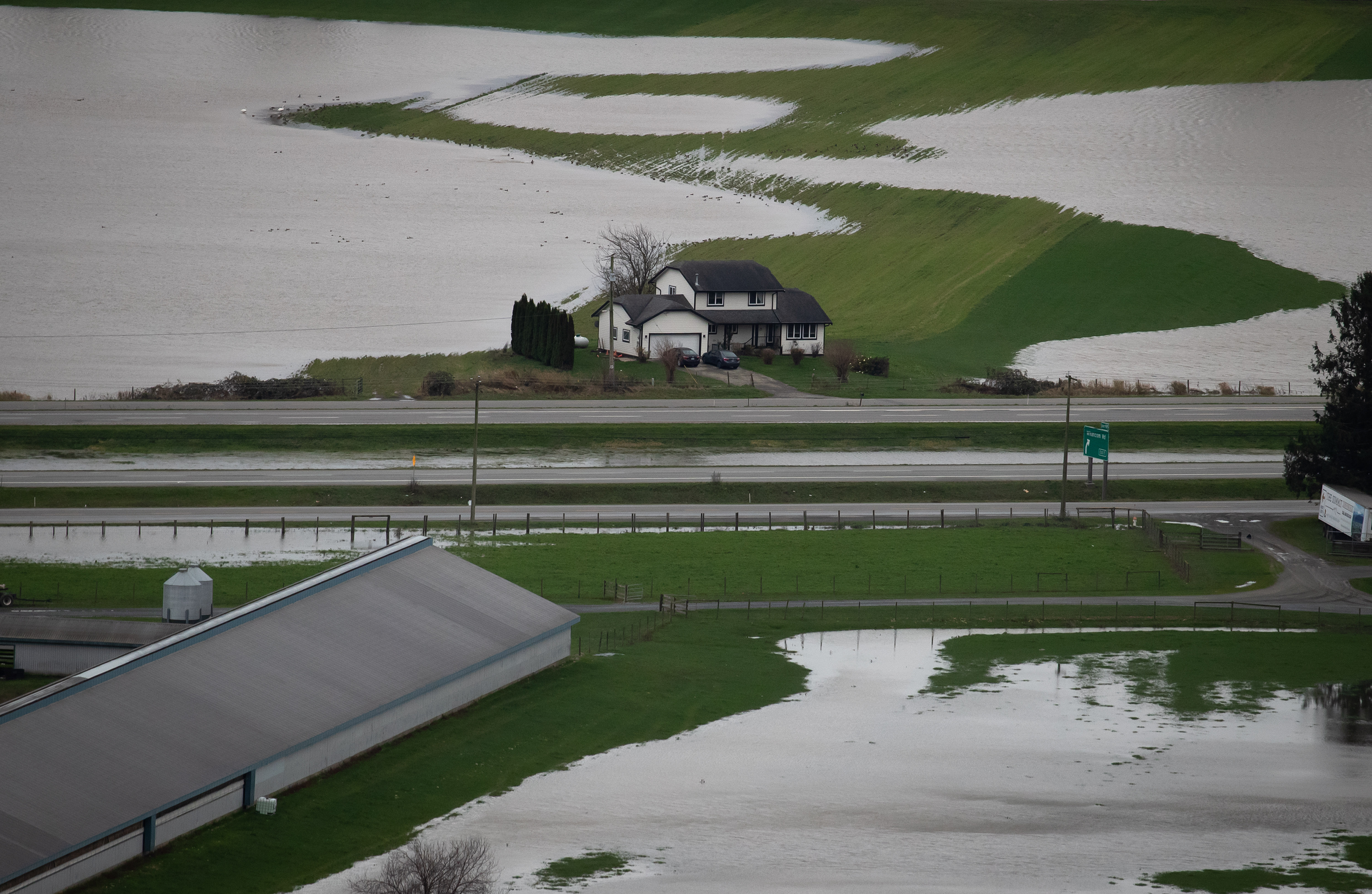 A house sits on high ground among flooded farmland in Abbotsford, B.C., on Wednesday, December 1, 2021.