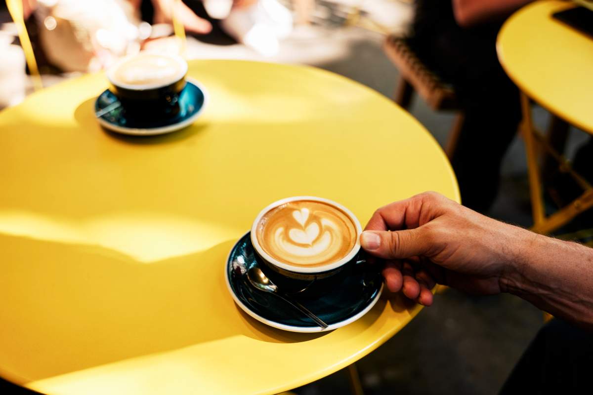 Two coffee mugs are seen on a cafe table.