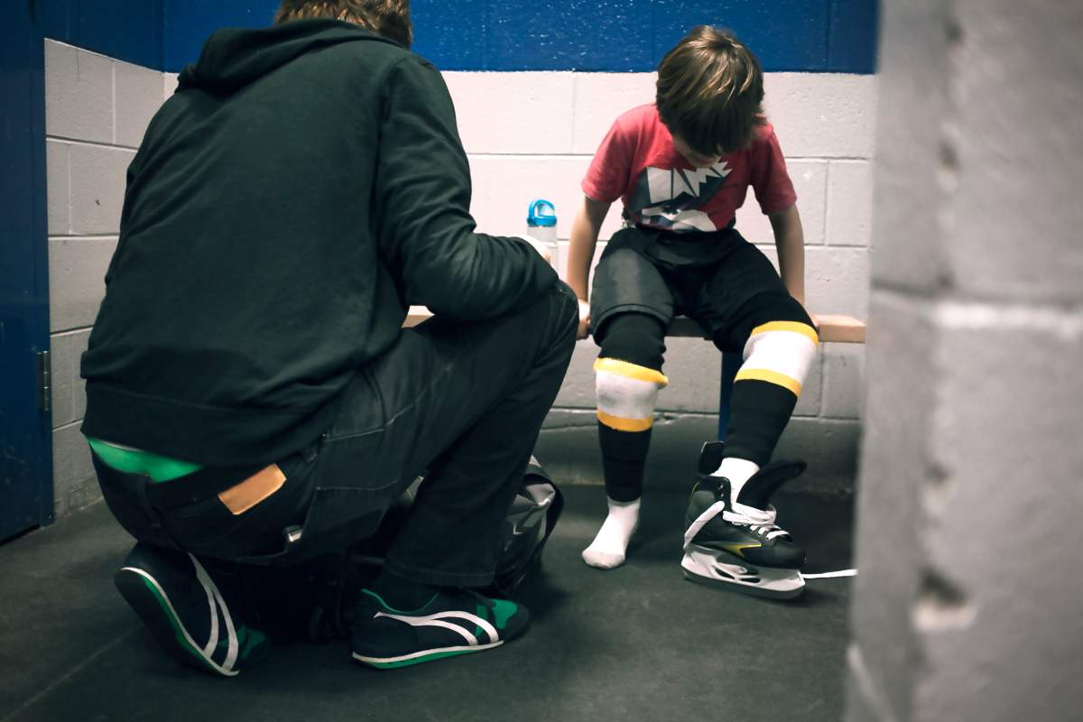 Father helping son with ice skates