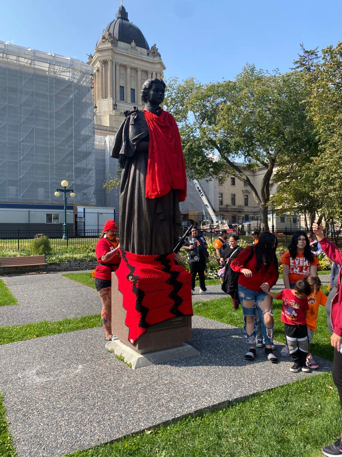 Red dress on the legislature’s statue of Queen Elizabeth during Monday’s protest.