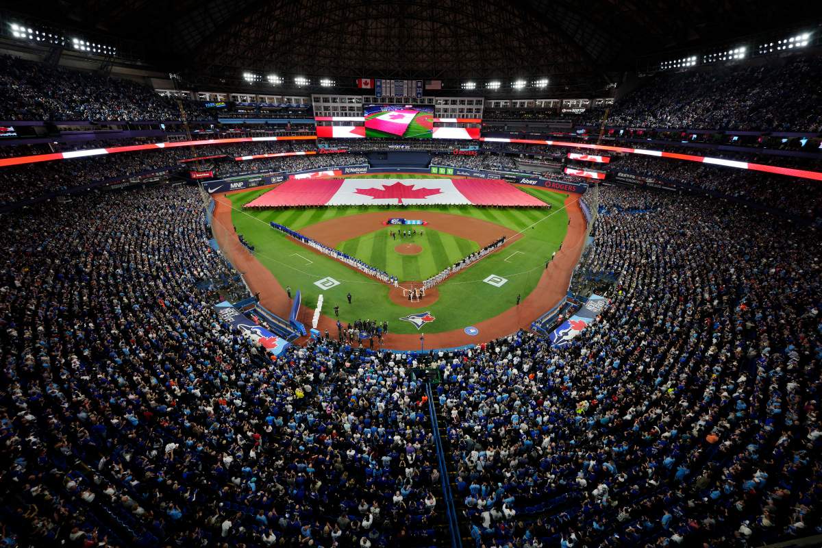 The Toronto Blue Jays and Detroit Tigers stand for the national anthem along with fans prior to the Blue Jays’ home opener in MLB American League baseball action in Toronto on Tuesday, April 11, 2023.