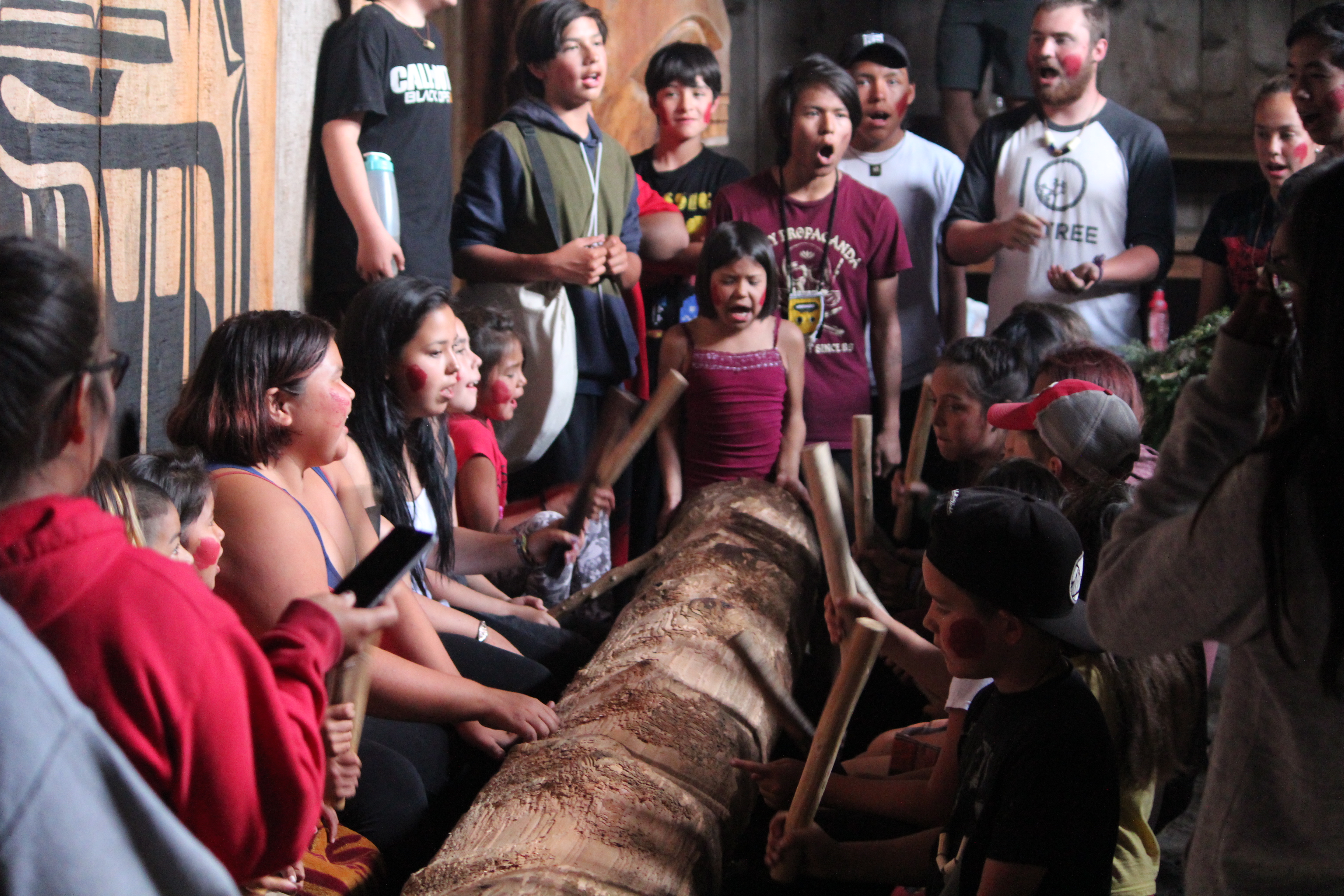 a group of children sit around a log