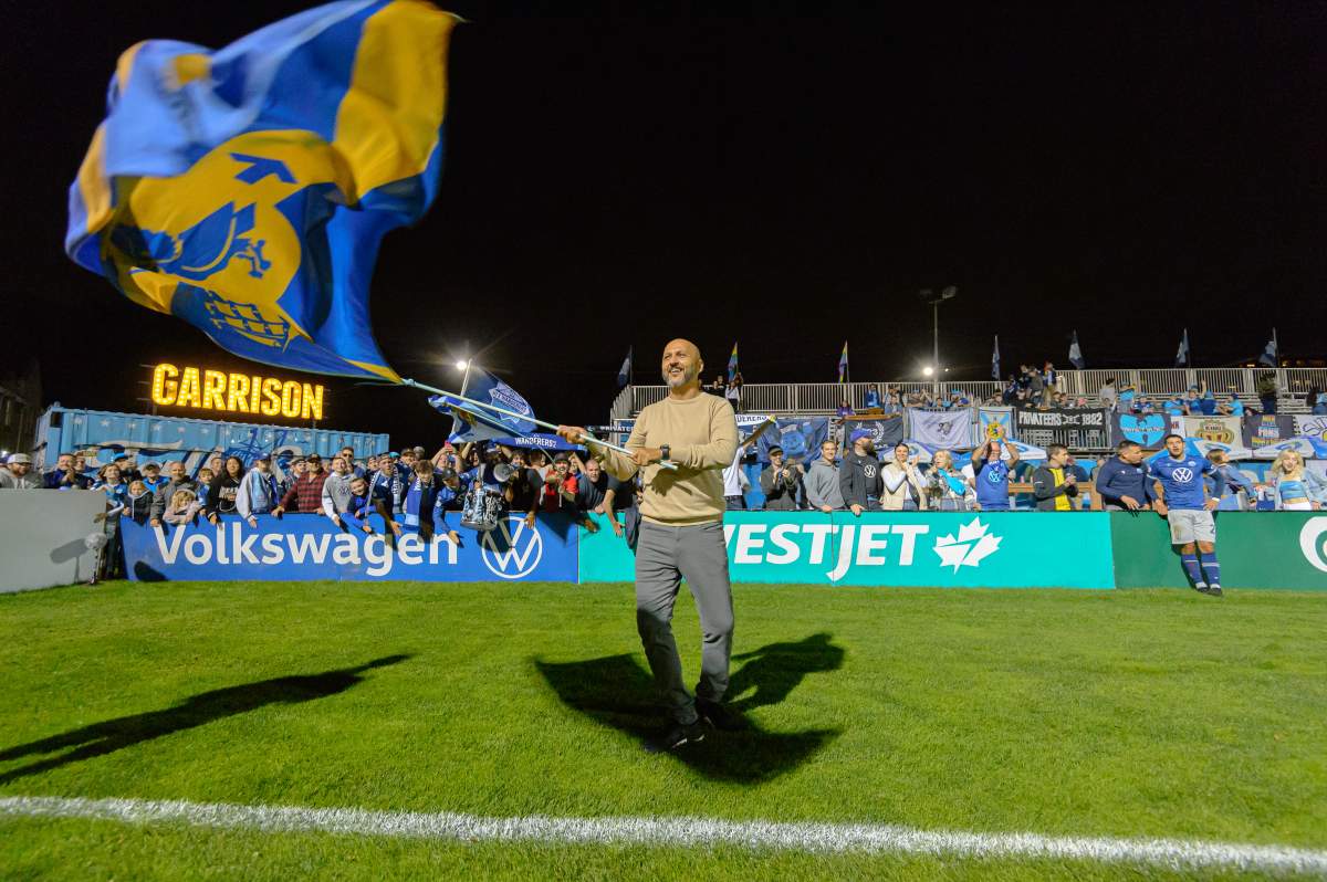 Halifax Wanderers head coach Patrice Gheisar waves the Halifax flag following a 3-2 victory of Atletico Ottawa on September 18, 2023, in Halifax, Nova Scotia. (Trevor MacMillan/HFX Wanderers FC)