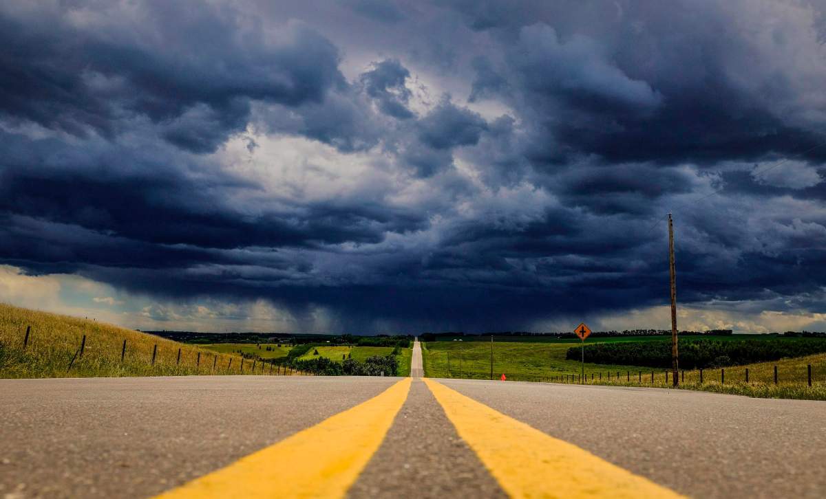 FILE: Storm clouds build over a highway in southern Alberta near the town of Carstairs on Monday, July 4, 2016.