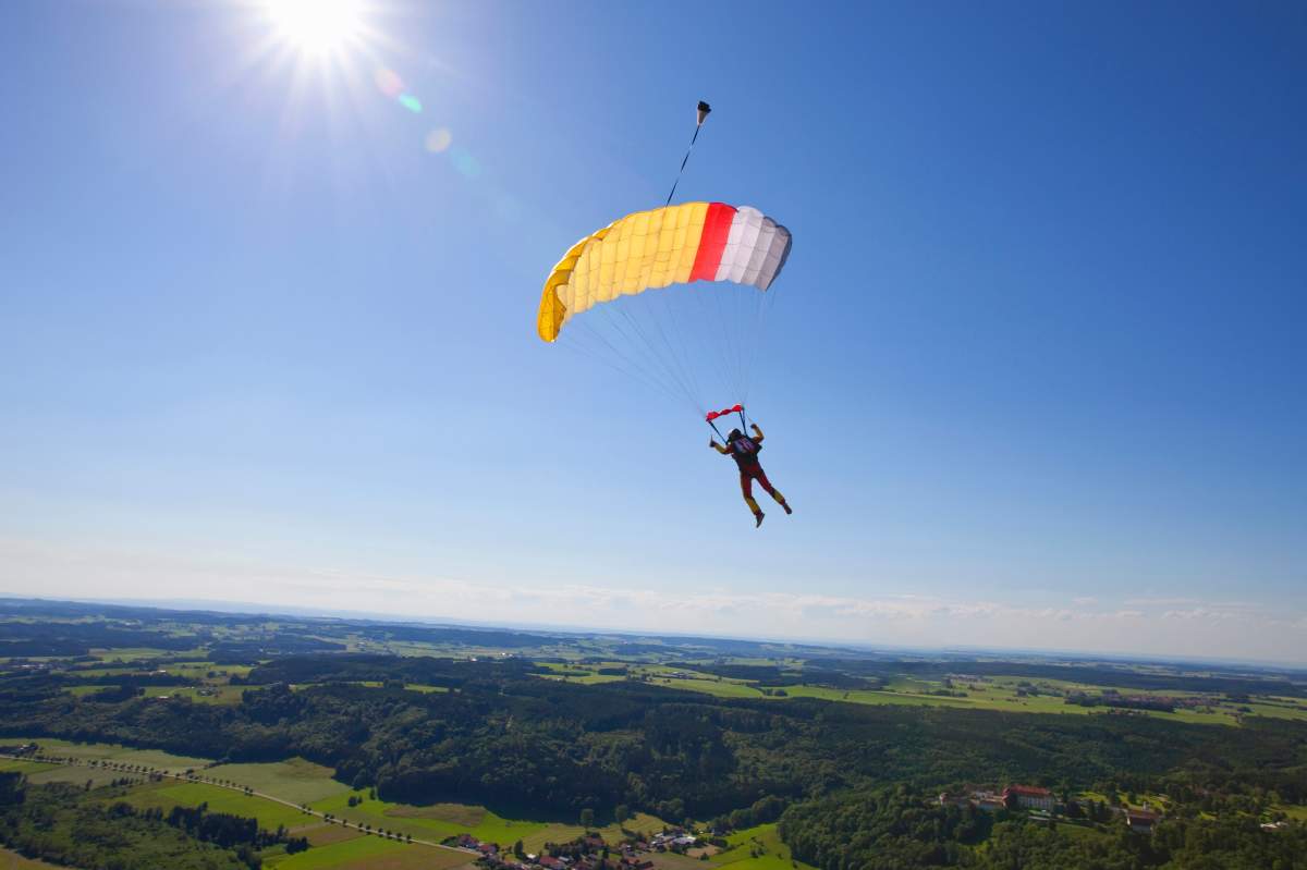 File photo of a man parachuting over green fields.
