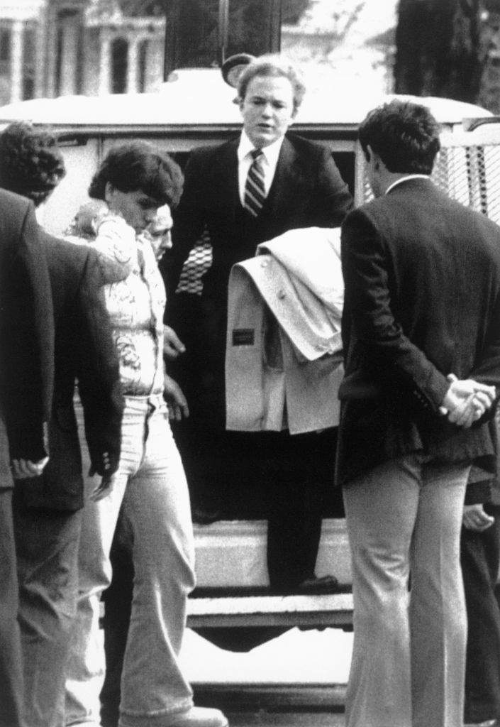 Arne C. Johnson, with coat over arm, steps from a police van on arrival at court in Danbury, Conn., for the opening day of his trial on the stabbing death of Alan Bono.