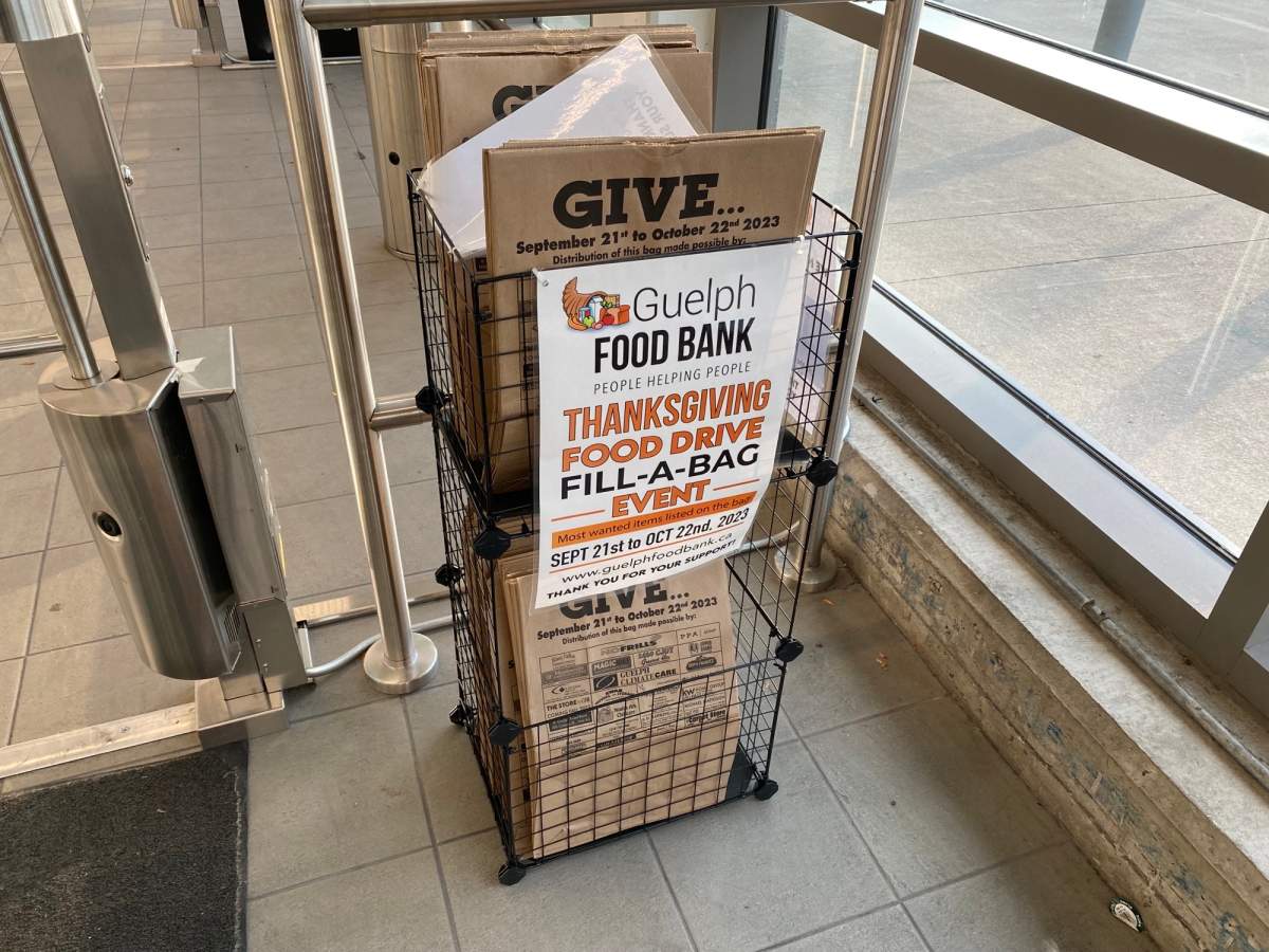 Stand inside Zehrs on Eramosa Rd. holding paper bag for Guelph Thanksgiving Food Drive.