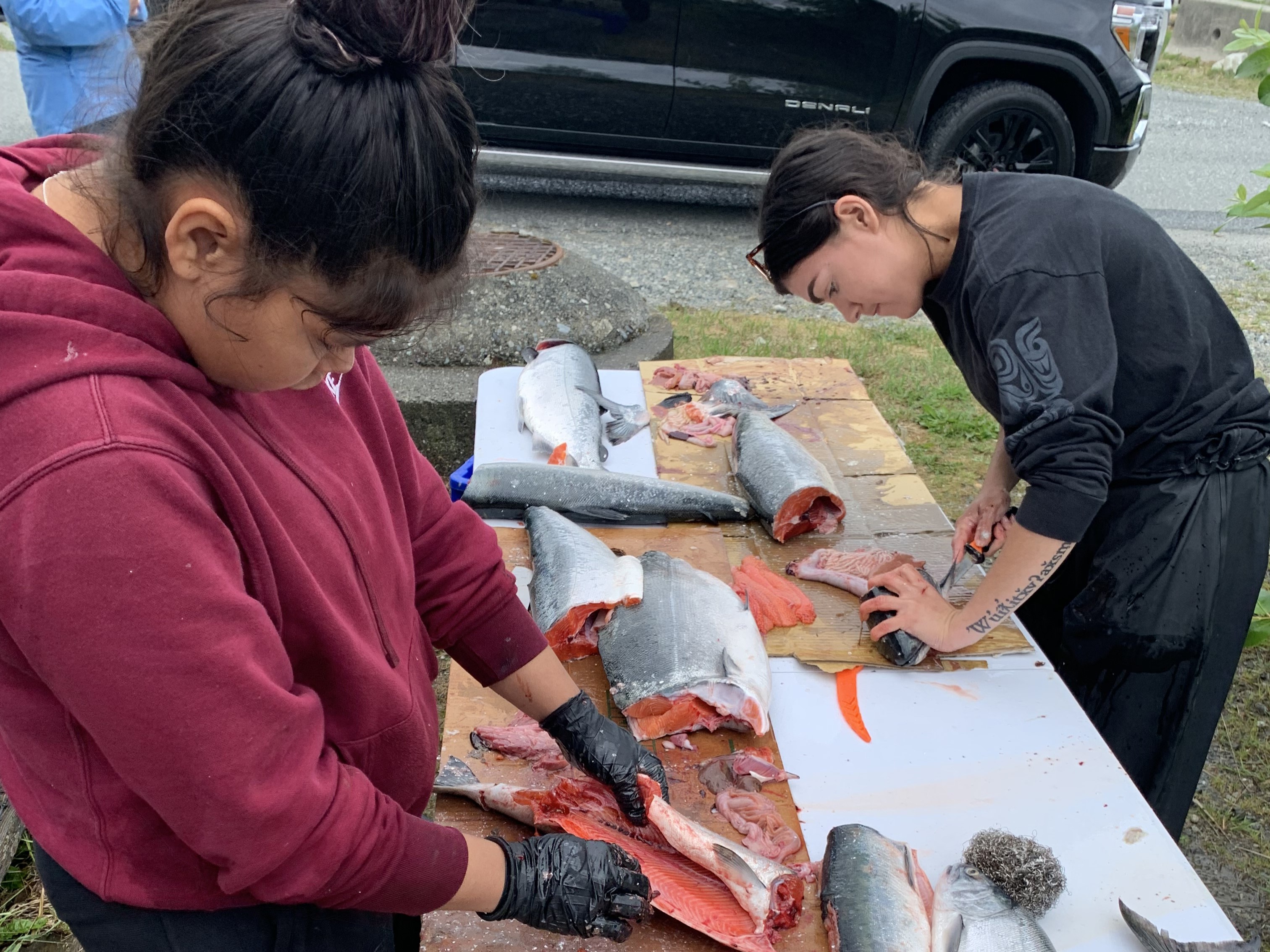 Two people gut fish on a table