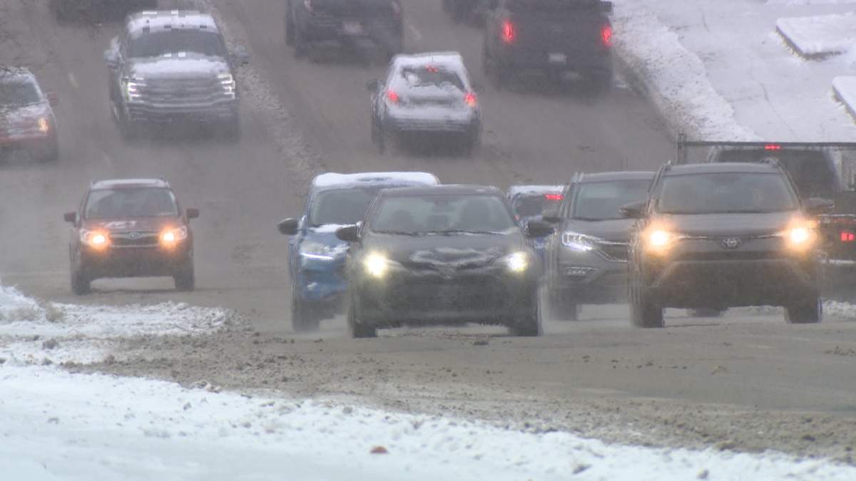 Vehicles make their way up a snow and ice covered 14th Street Northwest in Calgary on Oct. 24, 2023.