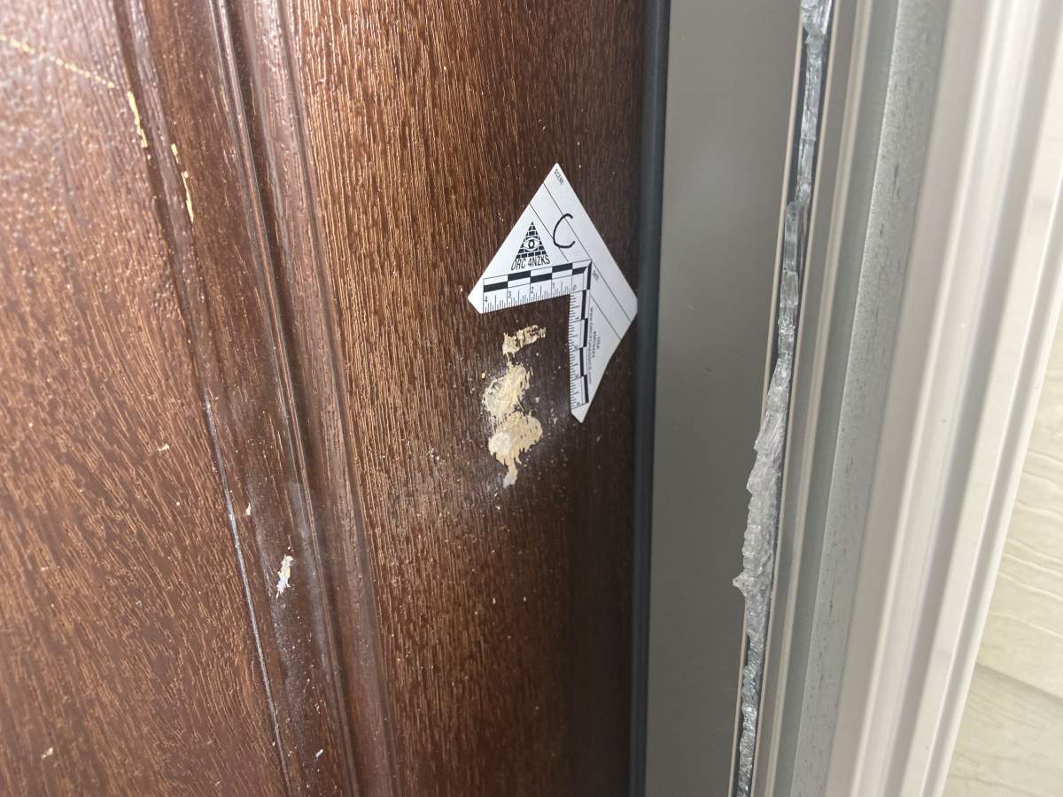 A photo of damage from bullets and a police marker. A house on Pinemill Way N.E. was damaged in a drive by shooting on Oct. 27, 2023.