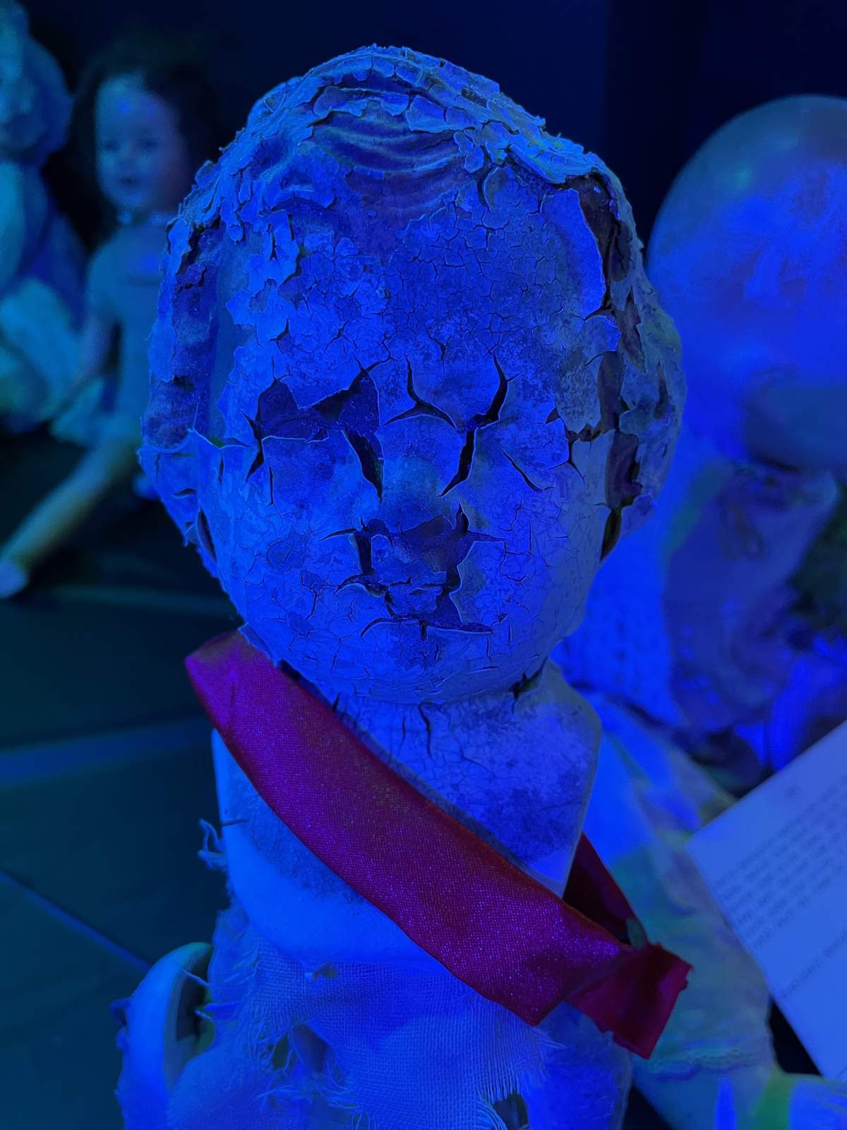 creepy doll with cracked face white eyes