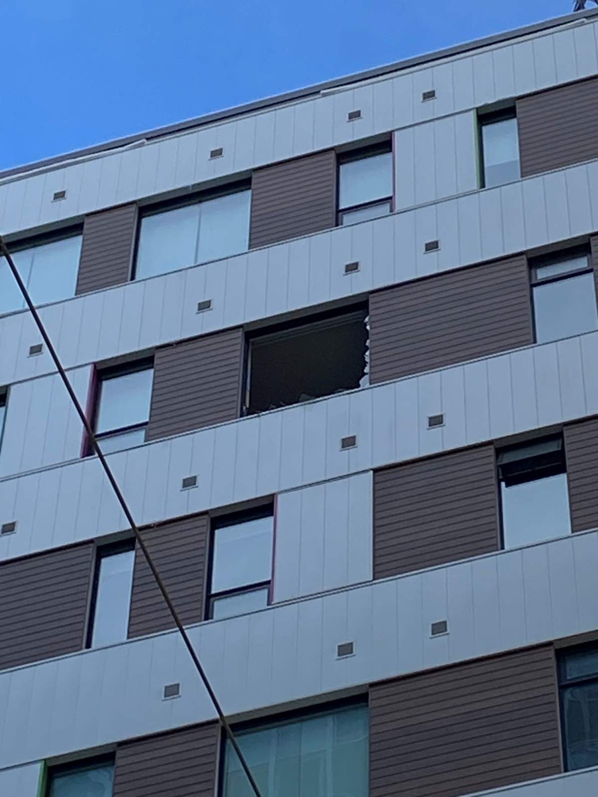 A damaged window of an apartment building in downtown Calgary after a coffee table fell nine storeys to the sidewalk below.