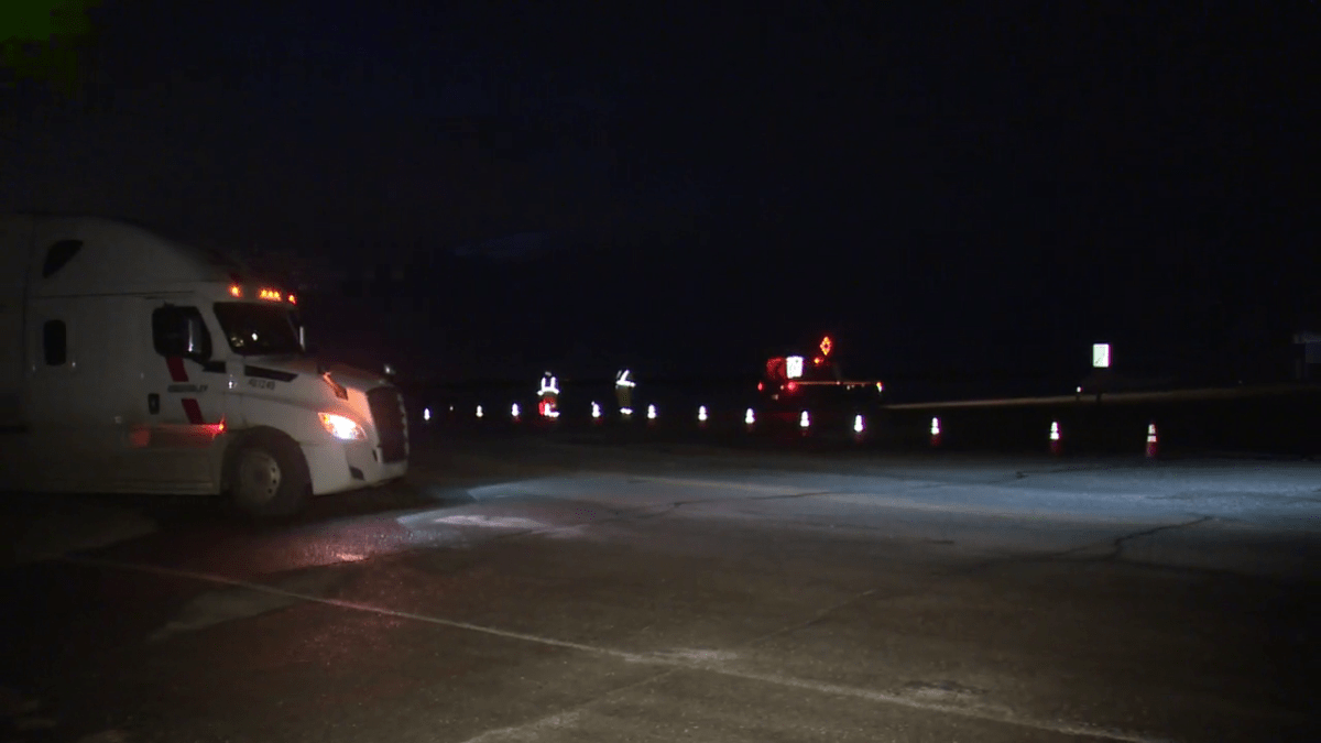Workers divert traffic off Highway 9 east of Calgary following a fatal collision on Oct. 30, 2023.