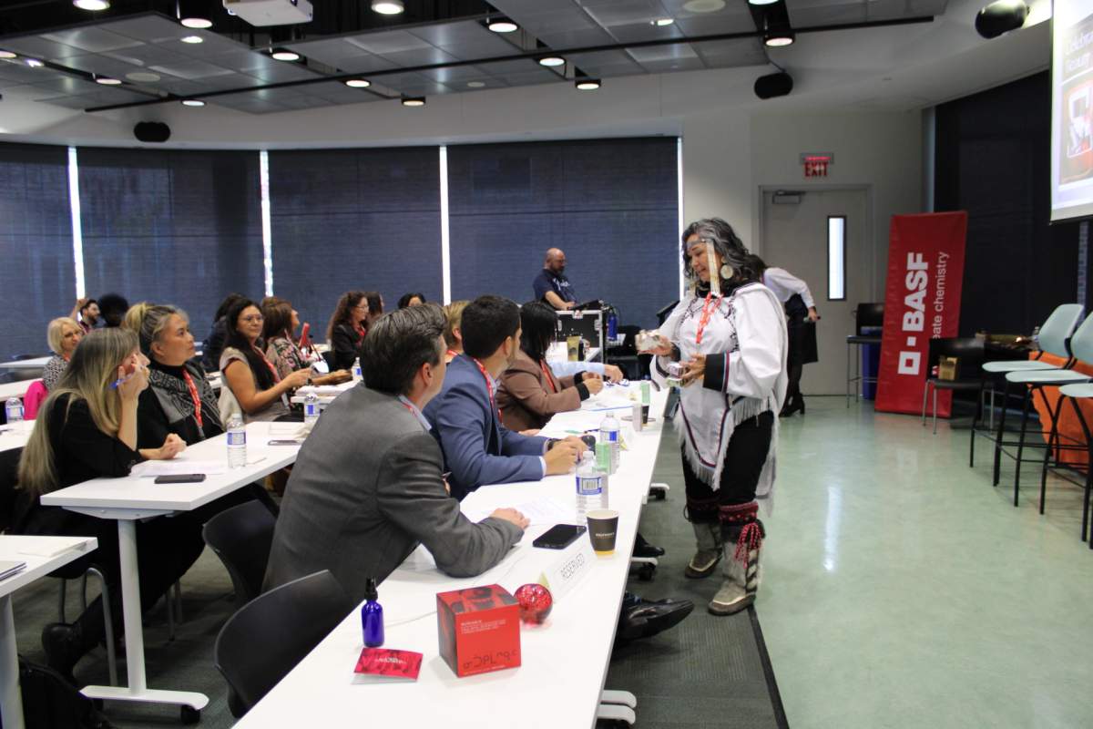 A woman shows items to people in a boardroom