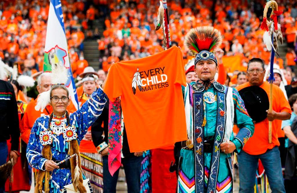 Sherry Starr and Wab Kinew lead the grand entrance at the second annual Orange Shirt Day Survivors Walk and Pow Wow in Winnipeg, Friday, Sept. 30, 2022.