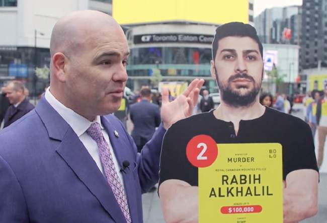 Staff Sgt. Lindsey Houghton stands next to a life-size cutout of Rabih Alkhalil