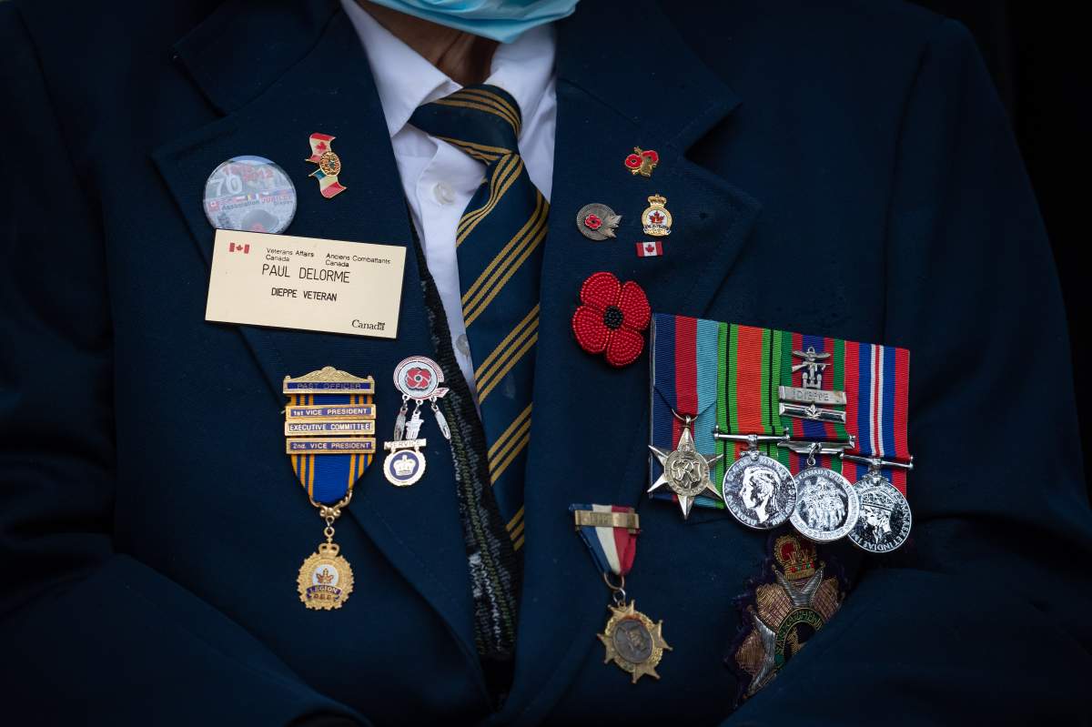 Second World War veteran Paul DeLorme, wears a beaded poppy along with his service medals and other pins during a Remembrance Day ceremony at Victory Square, in Vancouver in 2021.