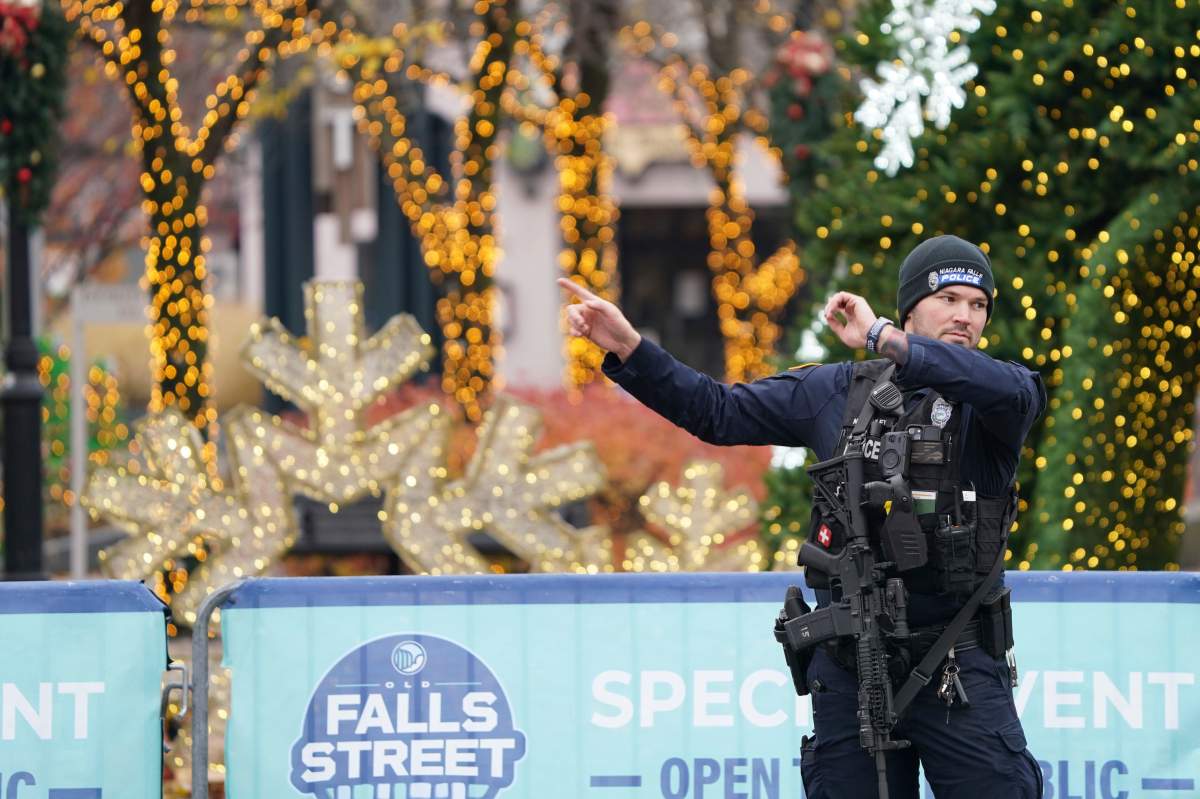 A Niagara Falls Police officer directs tourists in Niagara Falls, N.Y., away from the Rainbow Bridge border crossing after a car is reported to have exploded within the customs plaza, Wednesday, Nov. 22, 2023.