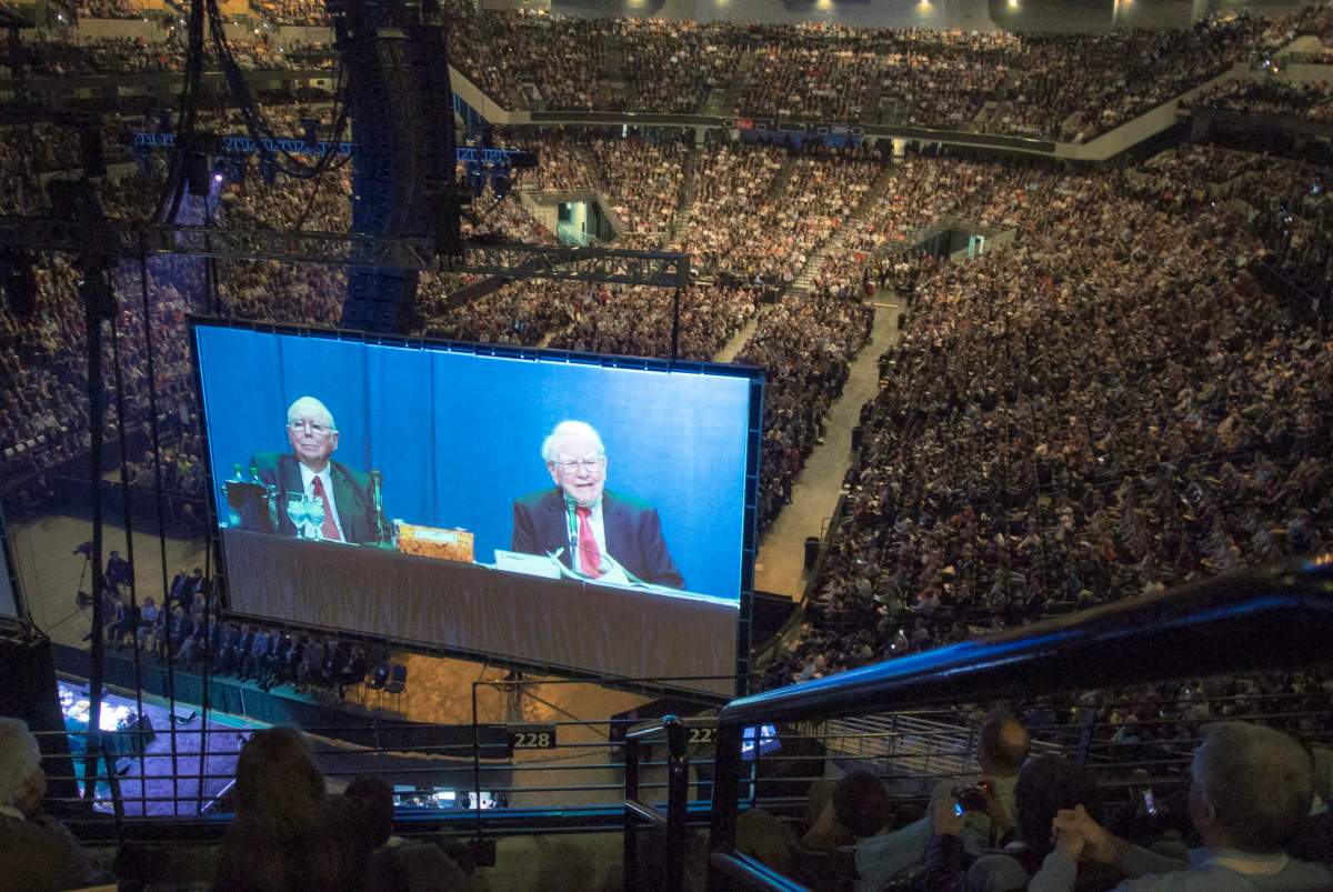 Berkshire Hathaway Chairman and CEO Warren Buffett, right, and his Vice Charman Charlie Munger are seen on a giant screen during the Berkshire Hathaway shareholders meeting in Omaha, Neb., Friday, May 3, 2013. Tens of thousands attend Berkshire Hathaway shareholder meeting to hear Warren Buffett and Charlie Munger answer questions for more than six hours. No other annual meeting can rival Berkshire’s, which is known for its size, the straight talk Buffett and Munger offer and the sales records shareholders set while buying Berkshire products. (AP Photo/Nati Harnik)