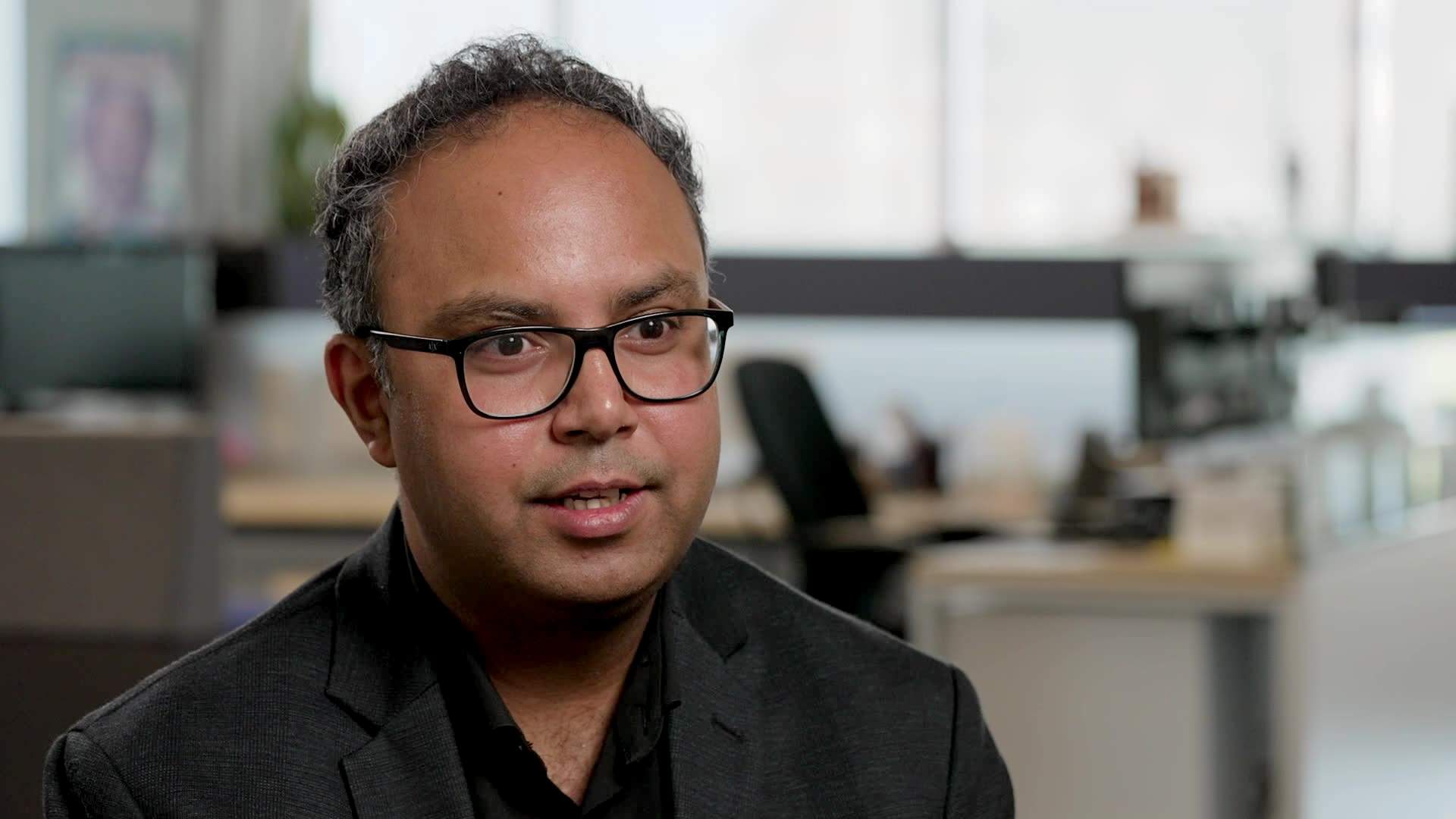 Deval Pandya, wearing glasses, sitting for an interview.