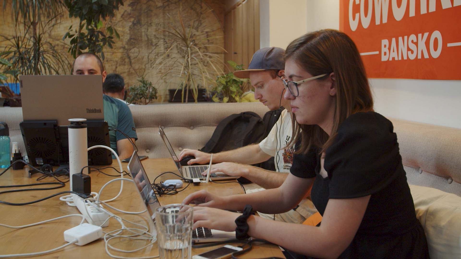 Several digital nomads working on their laptops in Coworking Bansko's lounge space.