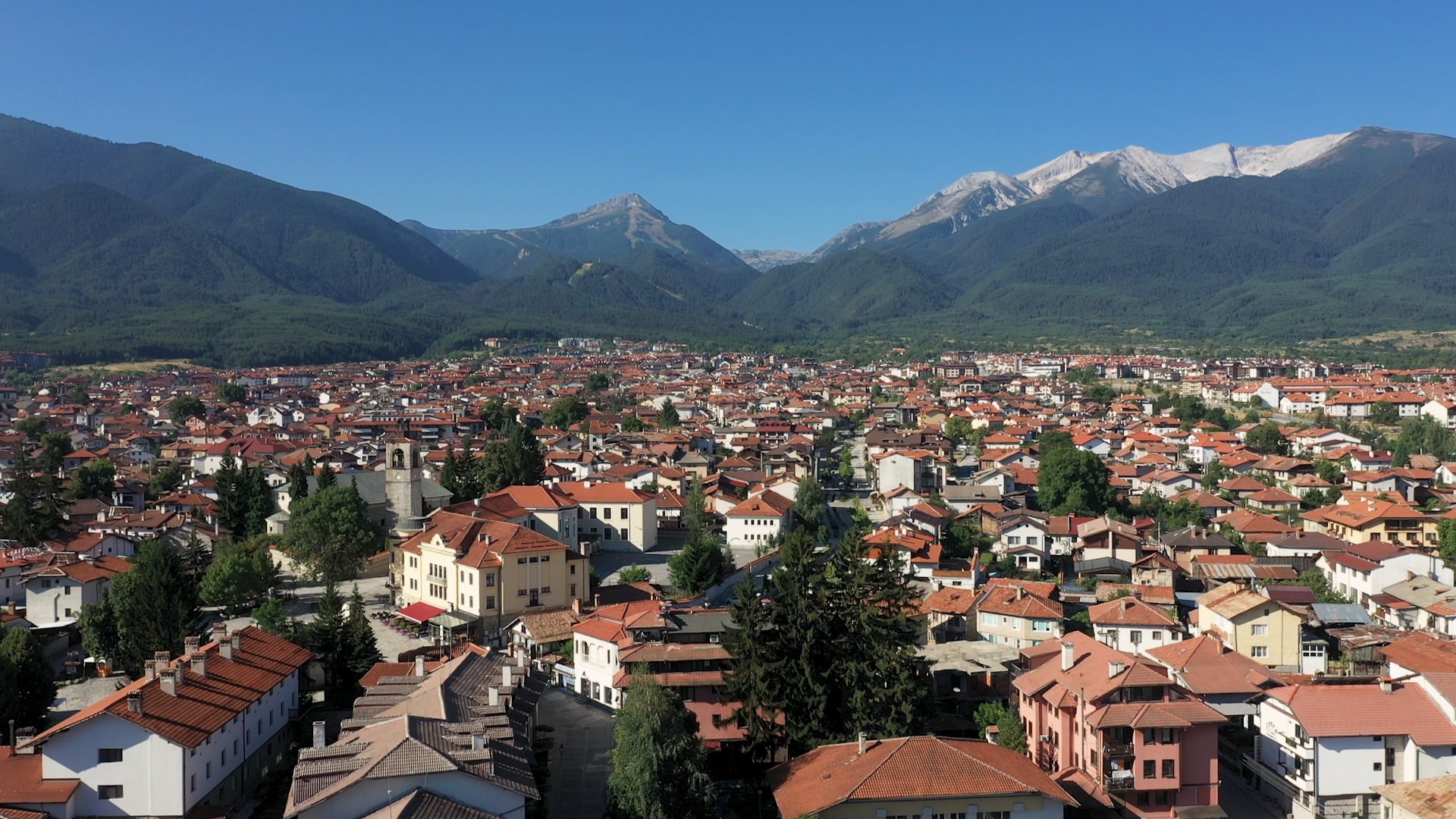 An aerial view of Bansko with the Pirin Mountain range in the background.