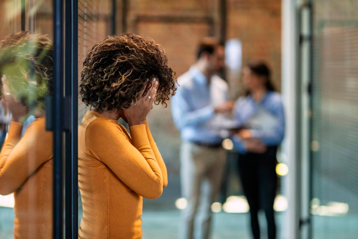 Woman upset with face in hands because she has been fired