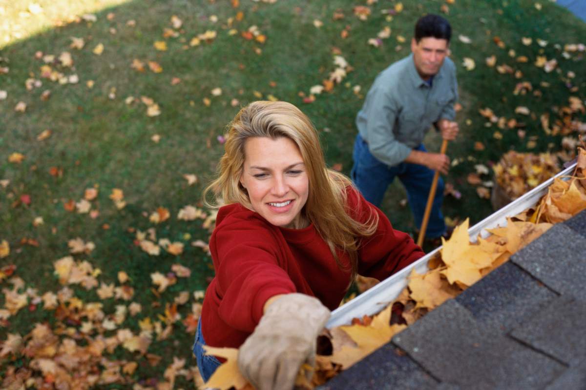 Woman cleaning gutter