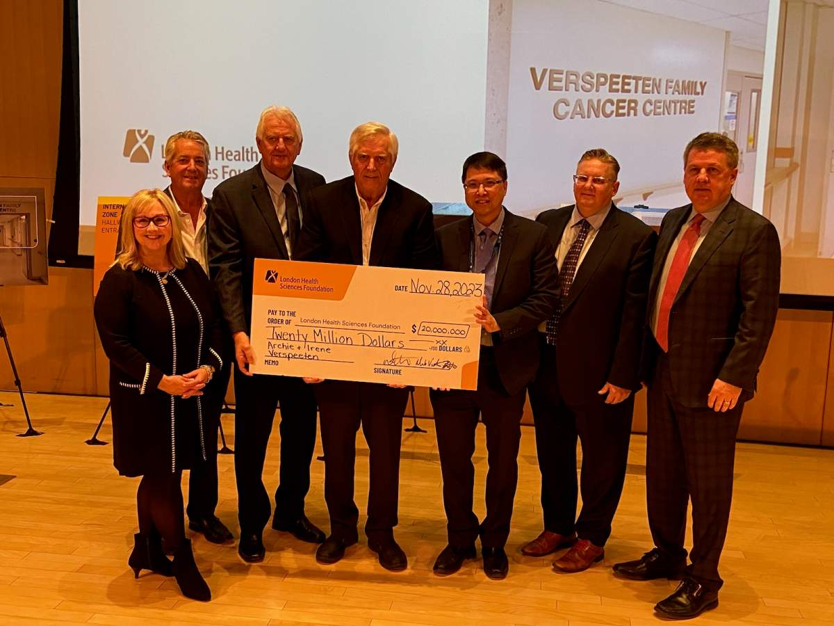 A group of people holding a large novelty cheque.