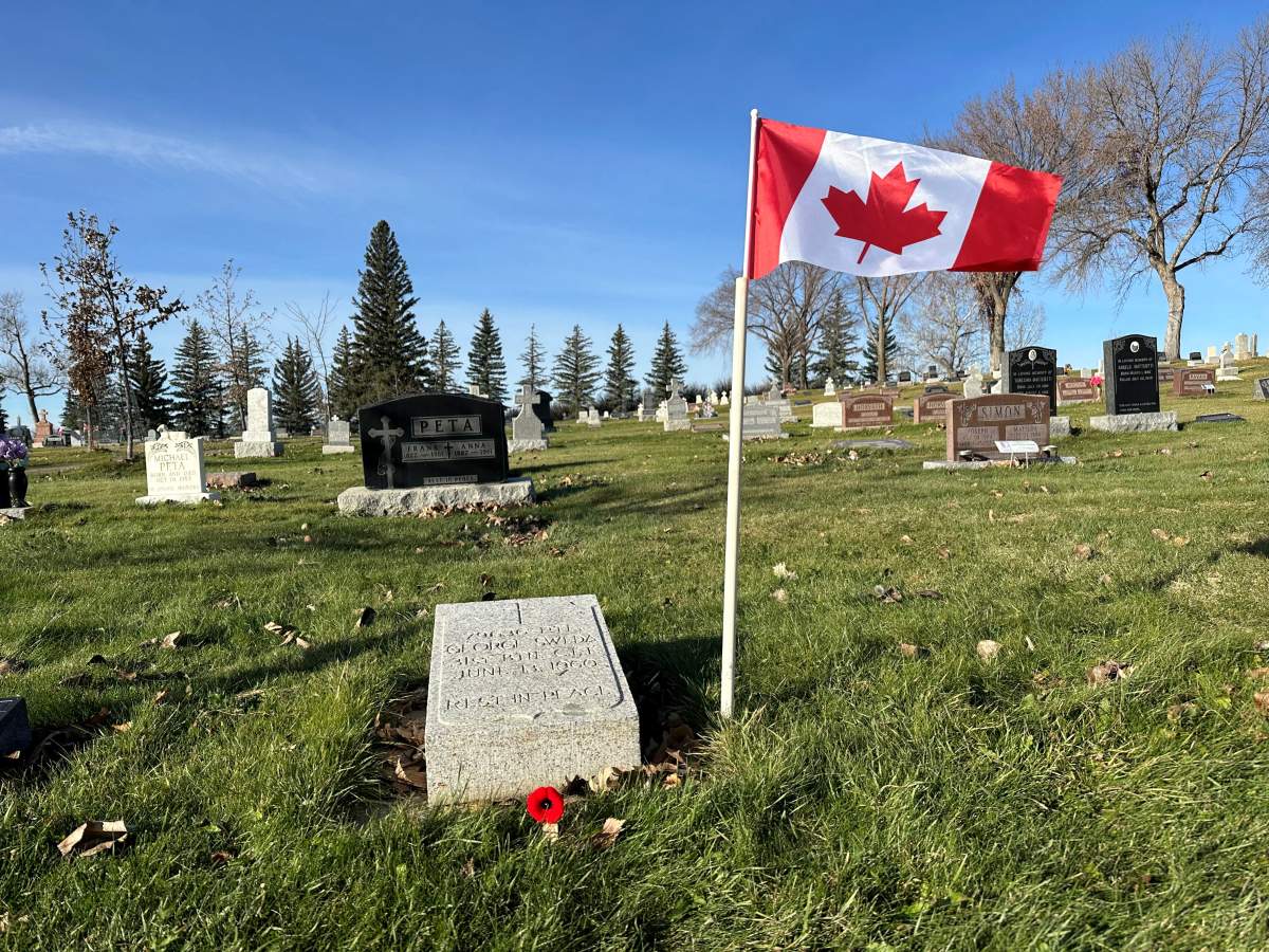 Stan Adamus places a Canadian flag and a poppy on all 35 veteran graves at St. Patrick’s cemetery in Lethbridge.