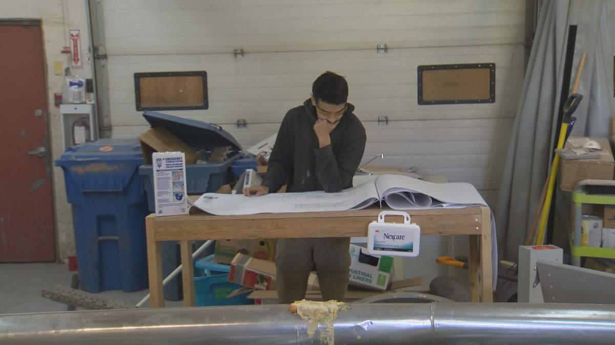 Alex Campbell looks over construction plans on a job site.