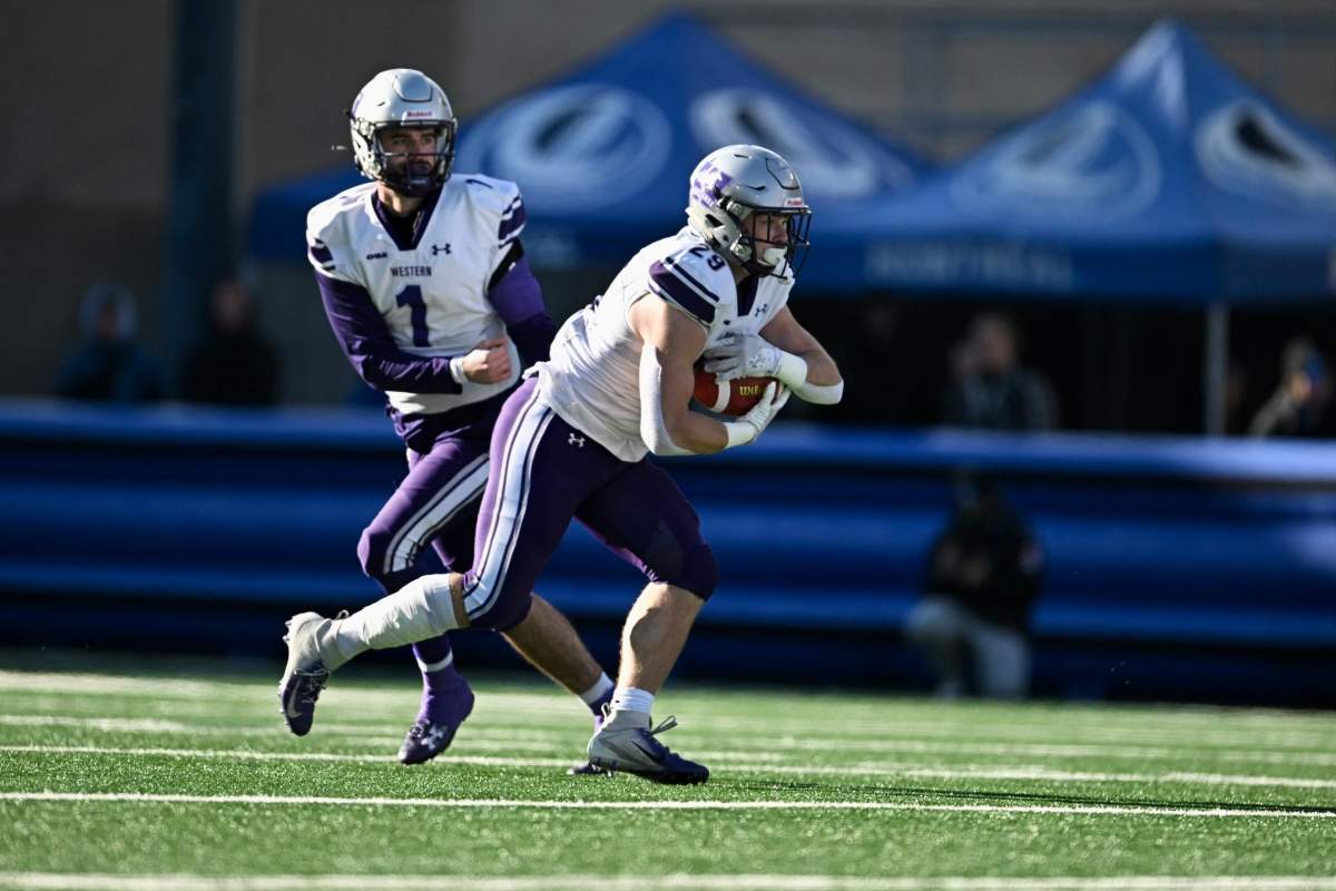 Western Mustang quarterback Evan Hillock hands the ball off in during a game on Nov. 18, 2023. On Aug. 25, the Mustangs handily beat the Gee-Gees in Ottawa.