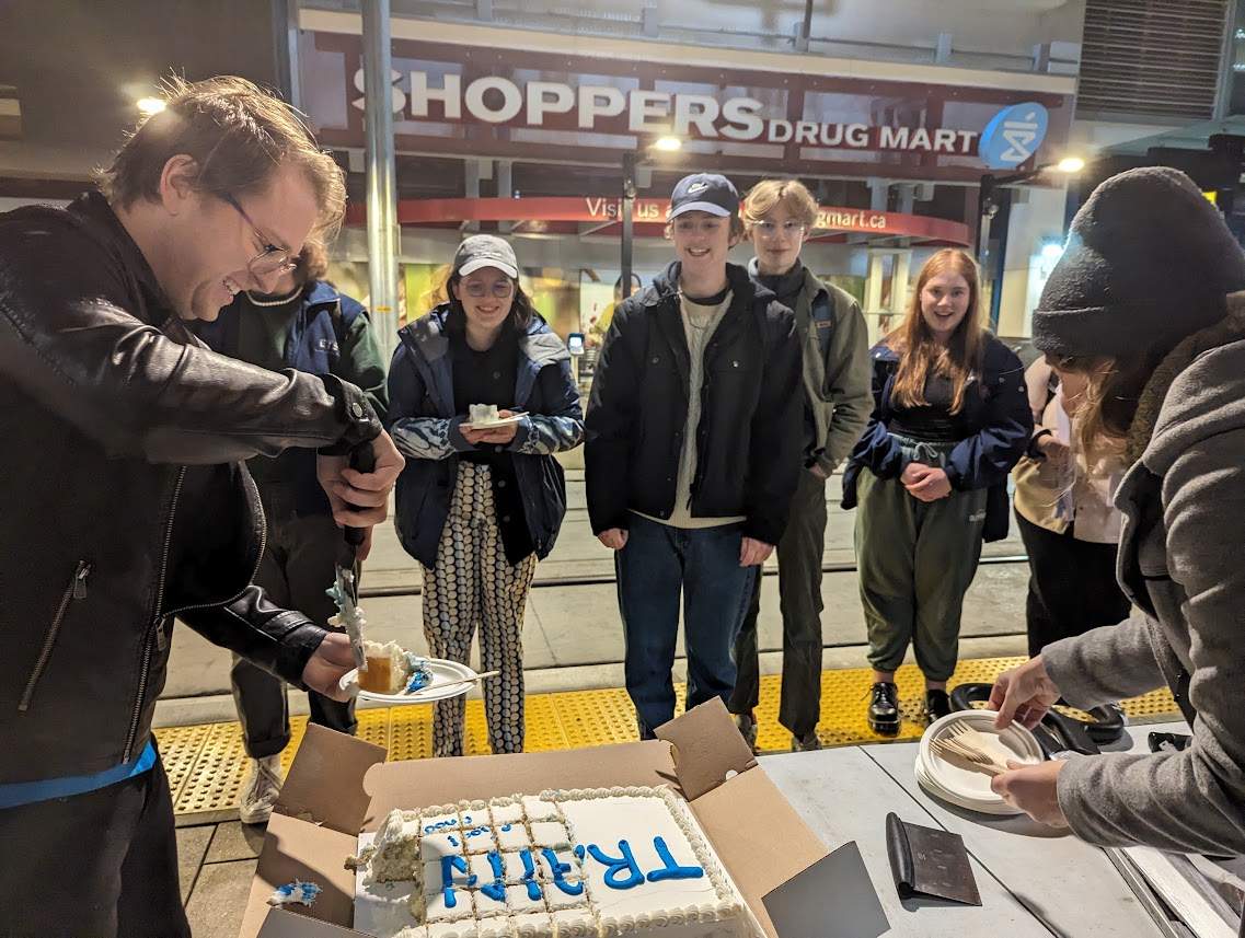 Passengers celebrate the opening of the Valley Line LRT with cake.