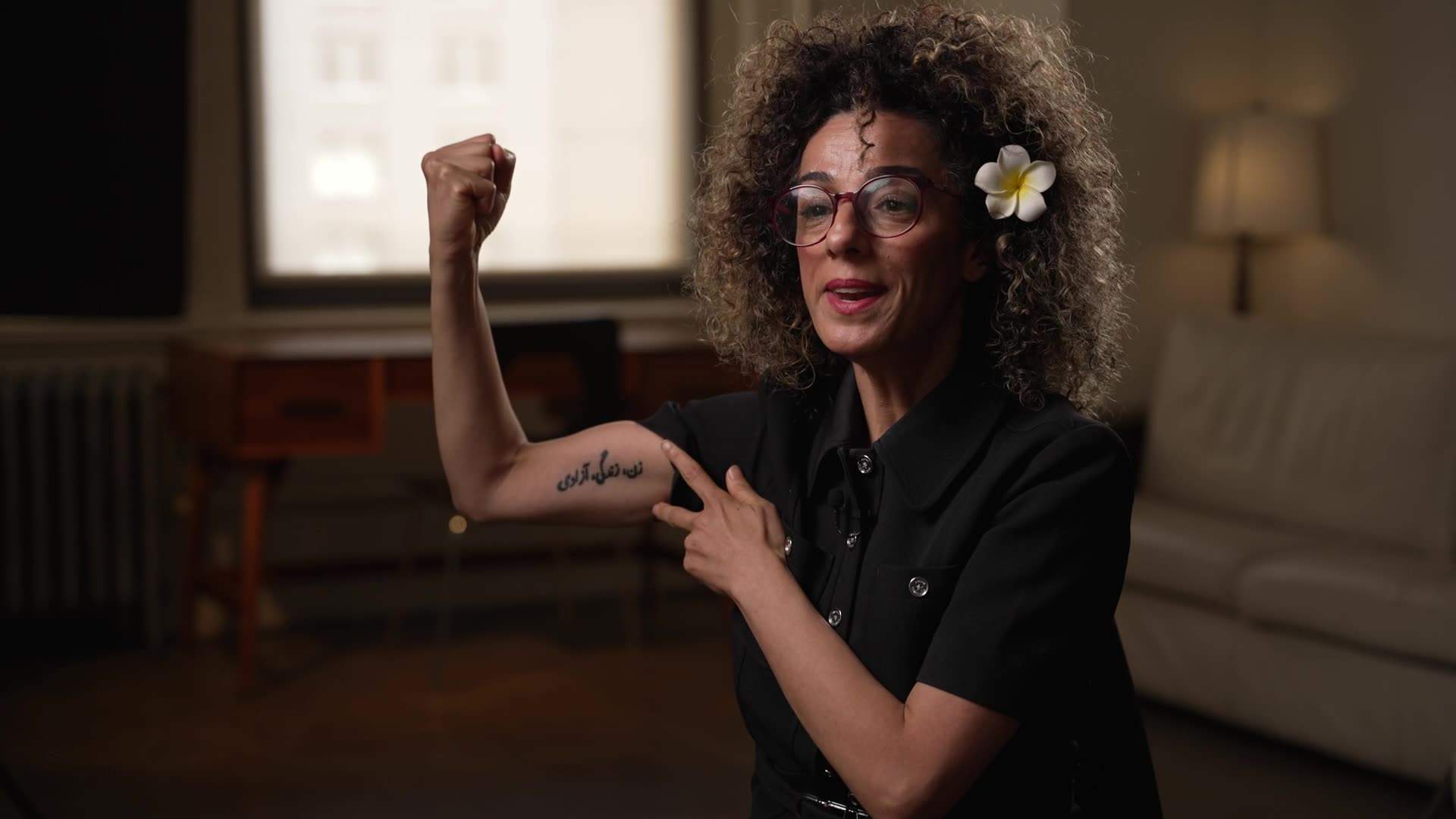 Masih Alinejad flexes her bicep tattooed in Farsi with “Woman, Life, Freedom” — a movement Alinejad forced the world to pay attention to, in defiance of Tehran’s violent suppression of women and girls.