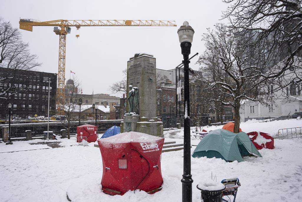 Red ice fishing enclosures are pictured at a tent encampment at Grand Parade in Halifax, Monday, Dec. 4, 2023.