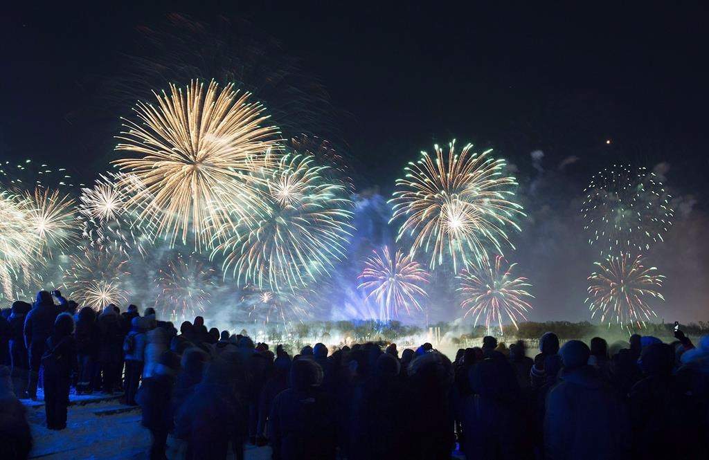 People look on as fireworks explode over Montreal’s Old Port during New Years Eve celebrations. There will be no midnight fireworks to herald the new year in Montreal’s Old Port.
