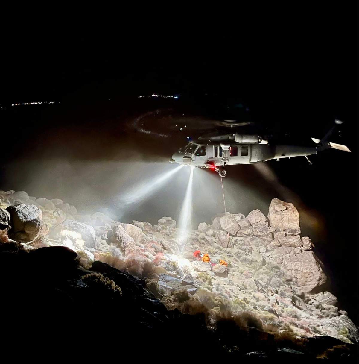 The scene of a rescue illuminated by helicopter light in the Inyo Mountains after a hiker became trapped under a boulder.