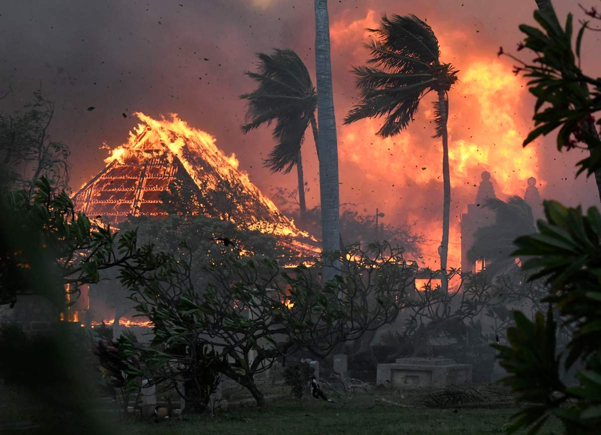 FILE – The hall of historic Waiola Church in Lahaina and nearby Lahaina Hongwanji Mission are engulfed in flames along Wainee Street on Aug. 8, 2023, in Lahaina, Hawaii. Communities still reeling from climate-fueled storms and other natural disasters, from the wildfires in Maui to severe flooding in New England, fear a federal government shutdown will delay needed disaster relief.(Matthew Thayer/The Maui News via AP, File)